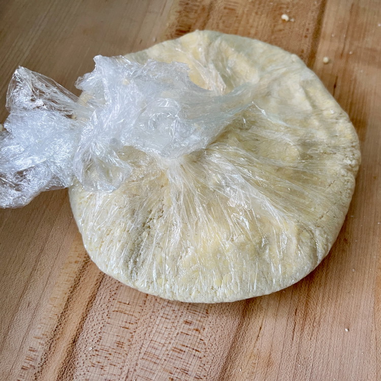 Image of As you bring the plastic in to the center to make the dough, make sure to press out excess air.